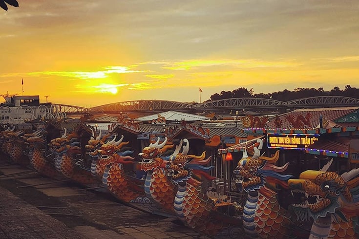 Dragon boats lined up on the Perfume River at sunset
