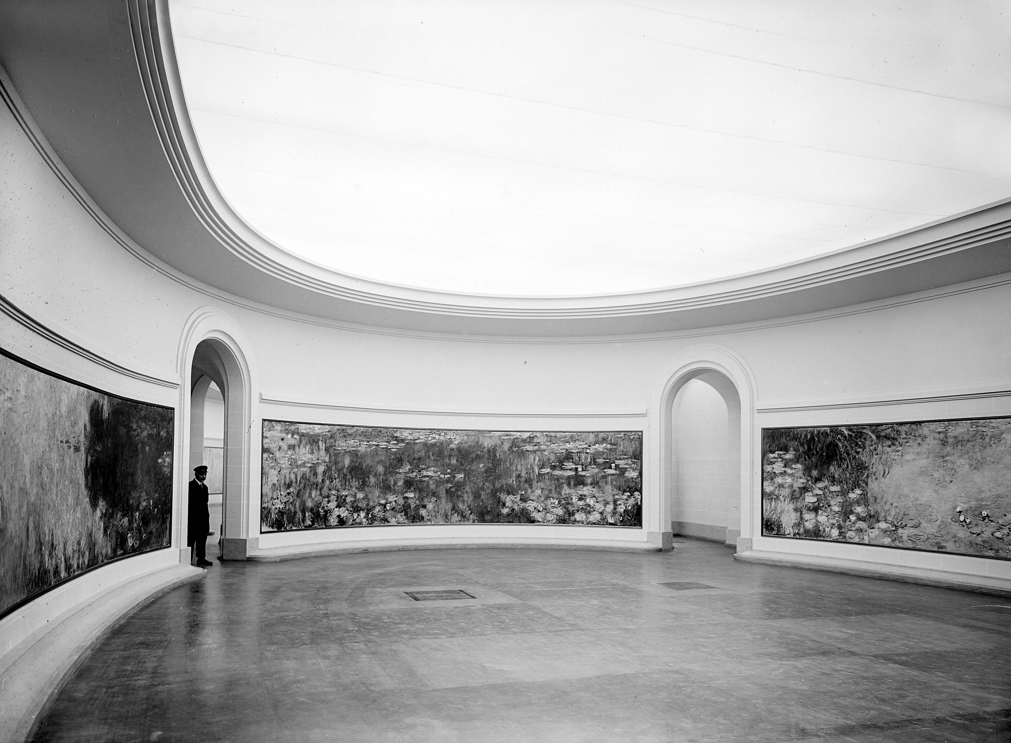 The first Water Lilies room, with one of the museum attendants, 1930 © Albert Harlingue / Roger-Viollet